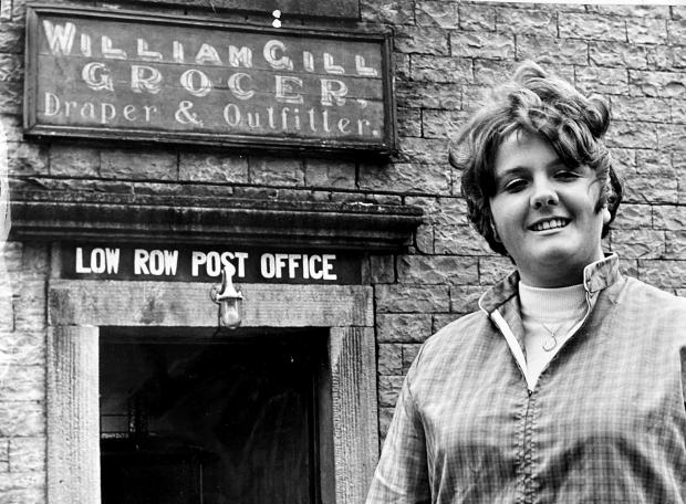 The Northern Echo: \"Mini-skirted\" Anne Gill outside Low Row Post Office in 1970 when, aged 19, she had become the youngest subpostmaster in the country. Her grandfather, William Gill, whose name can still be seen over the door advertising the non postal items that he